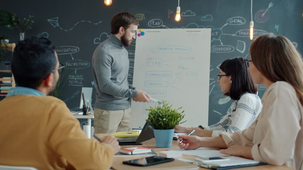 Team writing a digital marketing strategy on a whiteboard